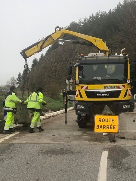 Pla general de diversos operaris acabant d'instal·lar les barreres de formigó a la carretera que va de Llívia a Estavar. Imatge de l'Ajuntament d'Estavar del 9 d'abril de 2020 (Vertical).