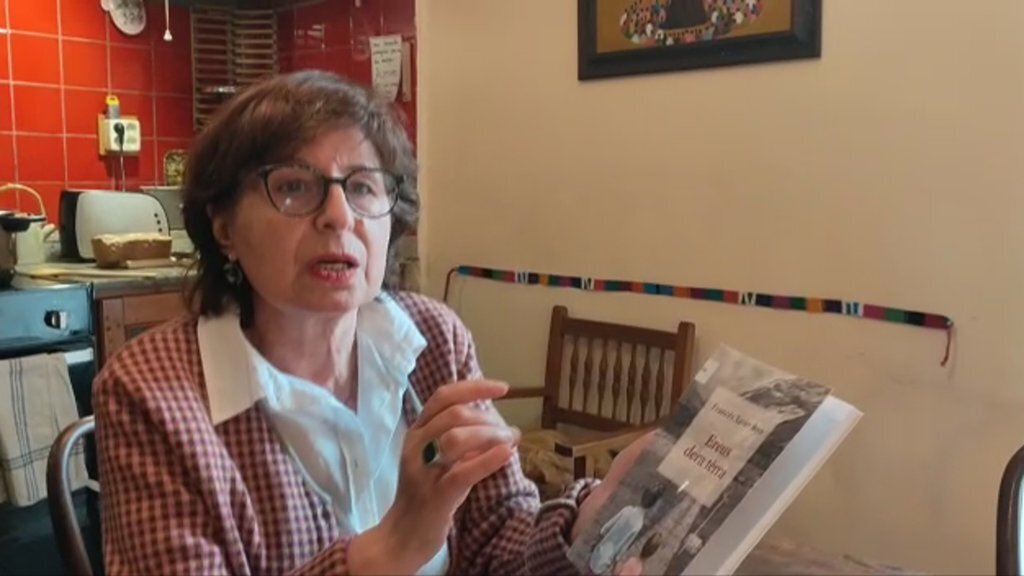 Pla mitjà de Maria Àngels Ros, bibliotecària de la Biblioteca de Salardú, mostrant 'Ereus dera terra', un dels llibres que recomana per aquest Sant Jordi. Imatge facilitada per Maria Àngels Ros el 20 d'abril de 2020 (Horitzontal).