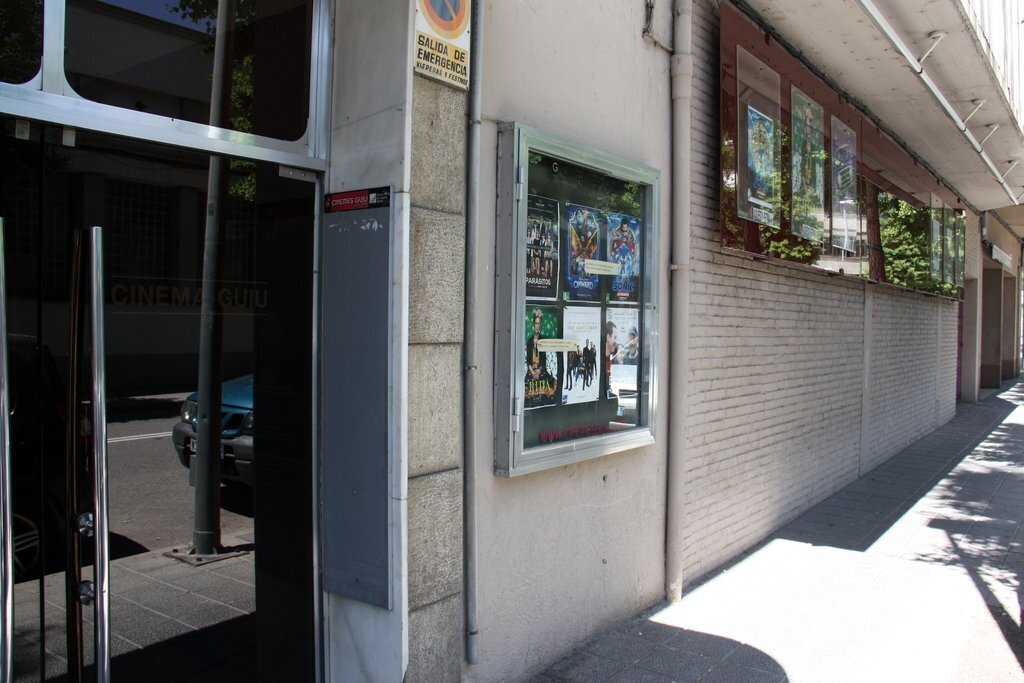 Pla obert de l'exterior dels Cinemes Guiu de la Seu d'Urgell on es veu la porta d'accés i la cartellera de pel·lícules. Imatge del 20 de maig de 2020 (Horitzontal).
