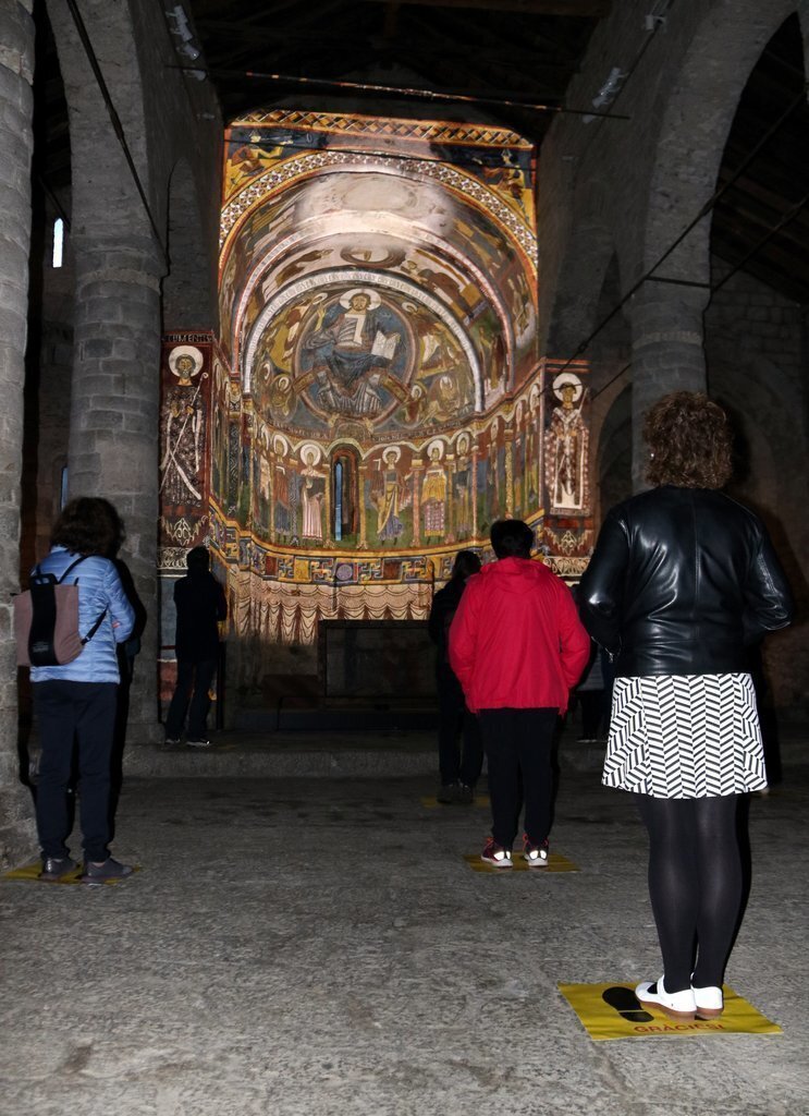 Visitants a l'interior de Sant Climent de Taüll (Alta Ribagorça) observant el vídeo mapping ubicats en uns punts assenyalats del terra el 4 de juny del 2020. (vertical)