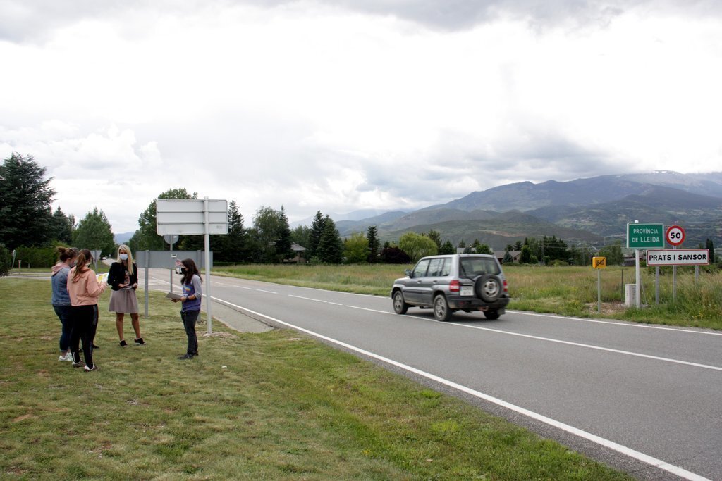 Pla general de diverses integrants de la Plataforma Docents Substituts de Cerdanya al costat del cartell que indica el límit provincial entre Lleida i Girona dins la comarca de la Cerdanya. Imatge del 10 de juny de 2020 (Horitzontal).