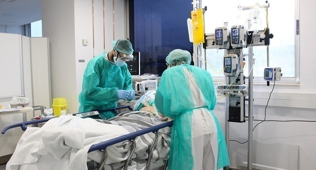 Pla mitjà de dos metges tenint cura d'un pacient amb coronavirus aquest dissabte 18 d'aril de 2020 a l'hospital Trueta. (Horitzontal)