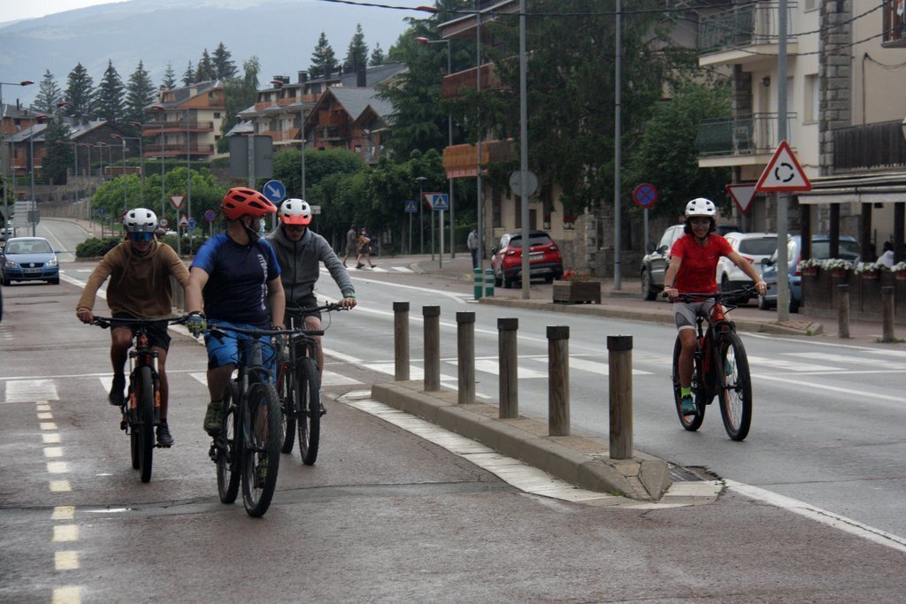 Pla general d'un grup de persones fent una ruta guiada en bicicleta per Llívia (Cerdanya). Imatge del 25 de juny de 2020 (Horitzontal).