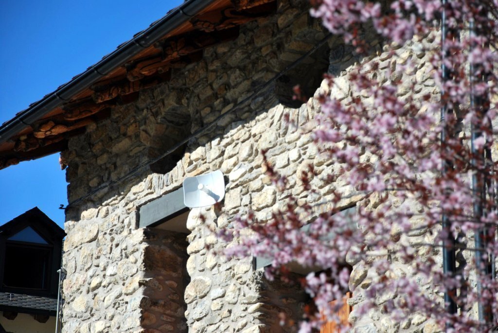 Detall d'una façana d'una casa amb una antena d'internet de Wicat. (horitzontal)