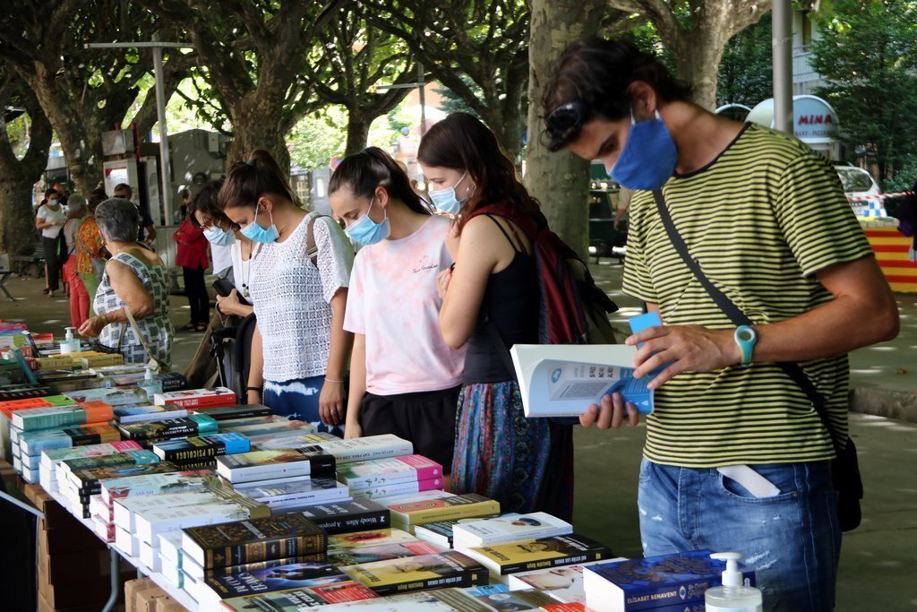 Gent mirant llibres a una parada de la Seu d'Urgell el 23 de juliol del 2020. (horitzontal)