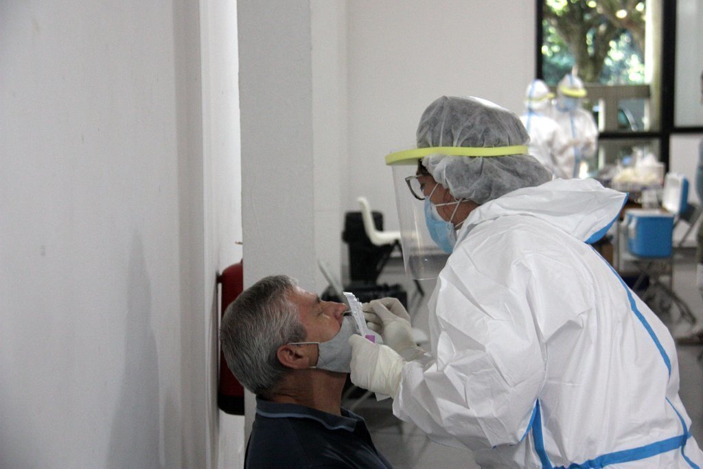 Pla de detall d'una persona i un professional sanitari mentre fan una PCR en el marc del cribratge massiu dut a terme al Centre Cívic el Passeig de la Seu d'Urgell. Imatge del 26 d'agost de 2020 (Horitzontal).
