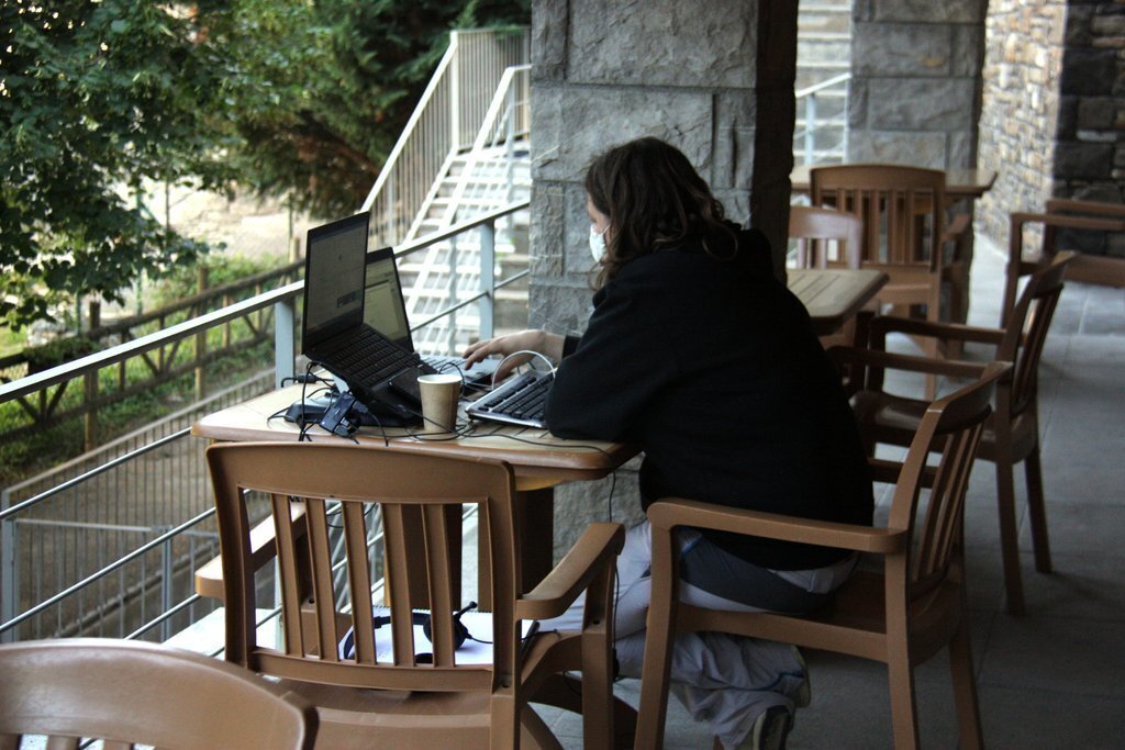 Pla obert de la zona de la terrassa que hi ha al costat de l'espai de 'coworking' de Prullans (Cerdanya) on es veu una persona treballant-hi. Imatge del 25 d'agost de 2020 (Horitzontal).