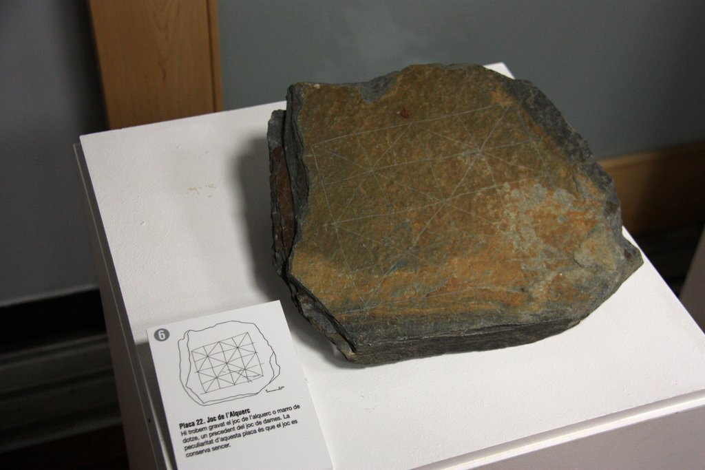 Pla de detall d'una les pissarres gravades del castell de Llívia que es poden veure en el marc d'una exposició sobre l'art rupestre de Cerdanya acompanyada d'un esbós que interpreta el dibuix de la pedra. Imatge del 7 d'octubre de 2020 (Horitzontal).