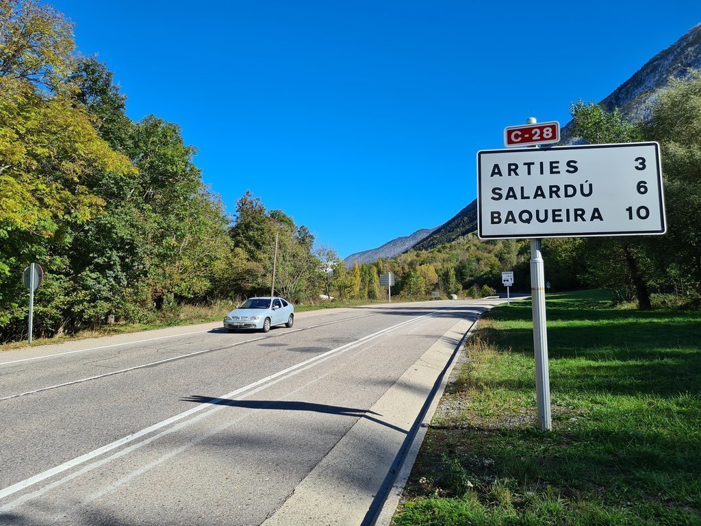 Pla obert on es pot veure un cartell amb indicacions a Arties, Salardú i Baqueira, a la C-28, a la Val d'Aran, el 16 d'octubre de 2020.