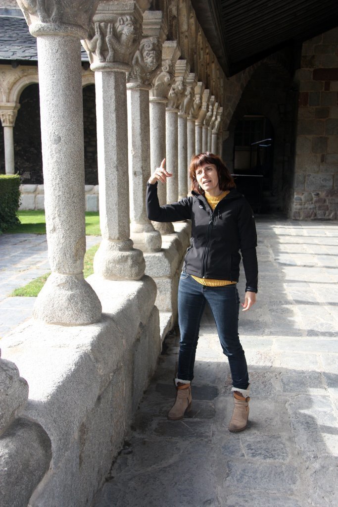 Pla general de la delegada de patrimoni del Bisbat d'Urgell, Clara Arbués, mostrant un dels capitells que hi ha als claustres de la Catedral de Santa Maria d'Urgell. Imatge del 12 de novembre de 2020 (Vertical).