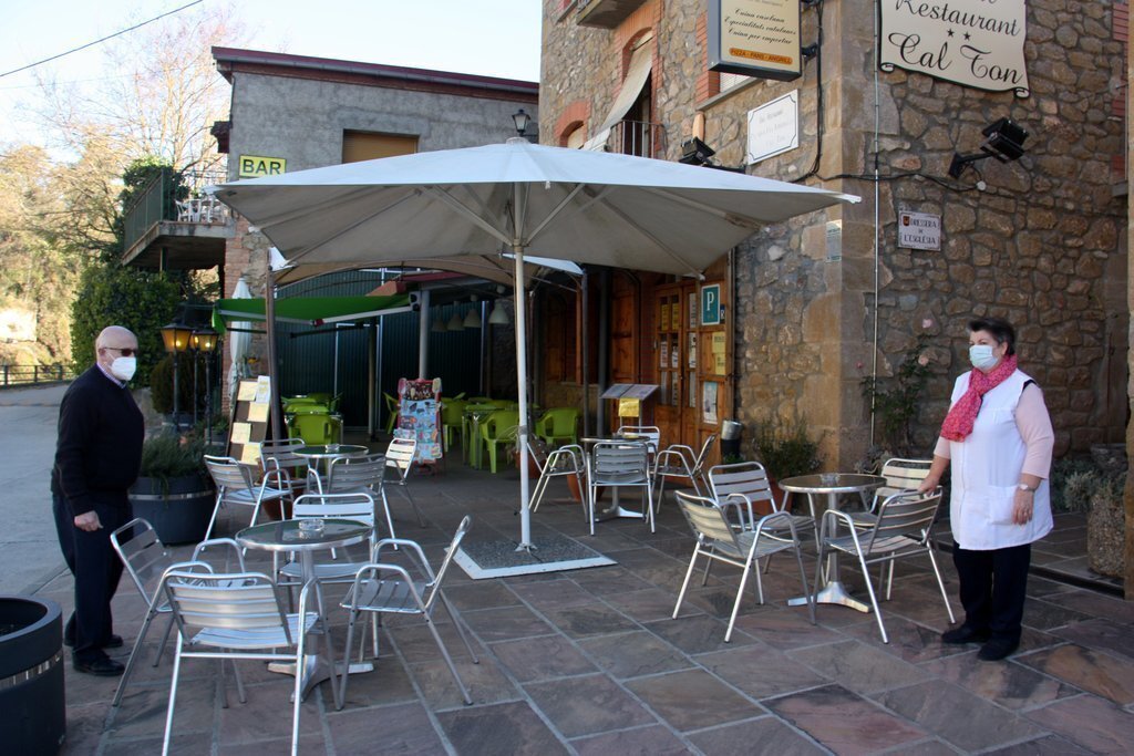 Pla general dels propietaris de l'Hostal Restaurant Cal Ton d'Ogern, a Bassella (Alt Urgell), acabant d'endreçar les taules de la terrassa en el primer dia de reobertura del sector de la restauració. Imatge del 23 de novembre de 2020 (Horitzontal).