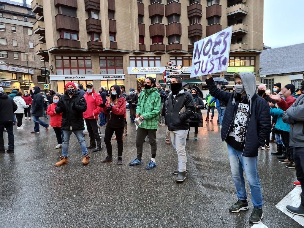 Pla de detall d'un manifestant amb un cartell on s'hi pot llegir 'No és just' el 21 de desembre del 2020. (horitzontal)