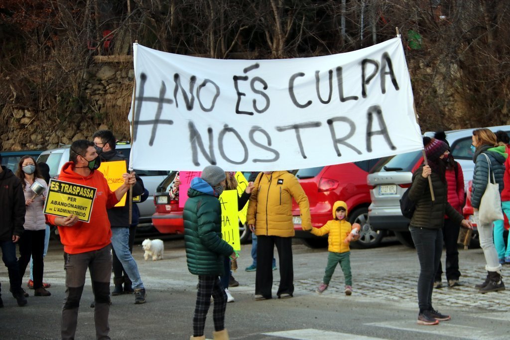 Pla general de manifestants a Taüll amb una pancarta on s'hi pot llegir 'No és culpa nostra' el 22 de desembre del 2020. (horitzontal)