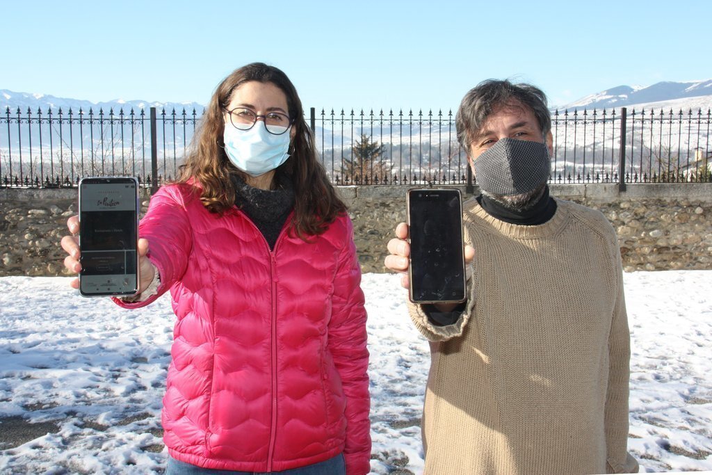 Pla mitjà de la tècnica del Consorci GAL Alt Urgell - Cerdanya, Eva Múrcia, i el tècnic dinamitzador agroalimentari del Consell Comarcal de la Cerdanya. Abel Solé, mostrant l'aplicació de 'La Piriteca' al seu mòbil, el 14 de gener de 2021 (Horitzontal).