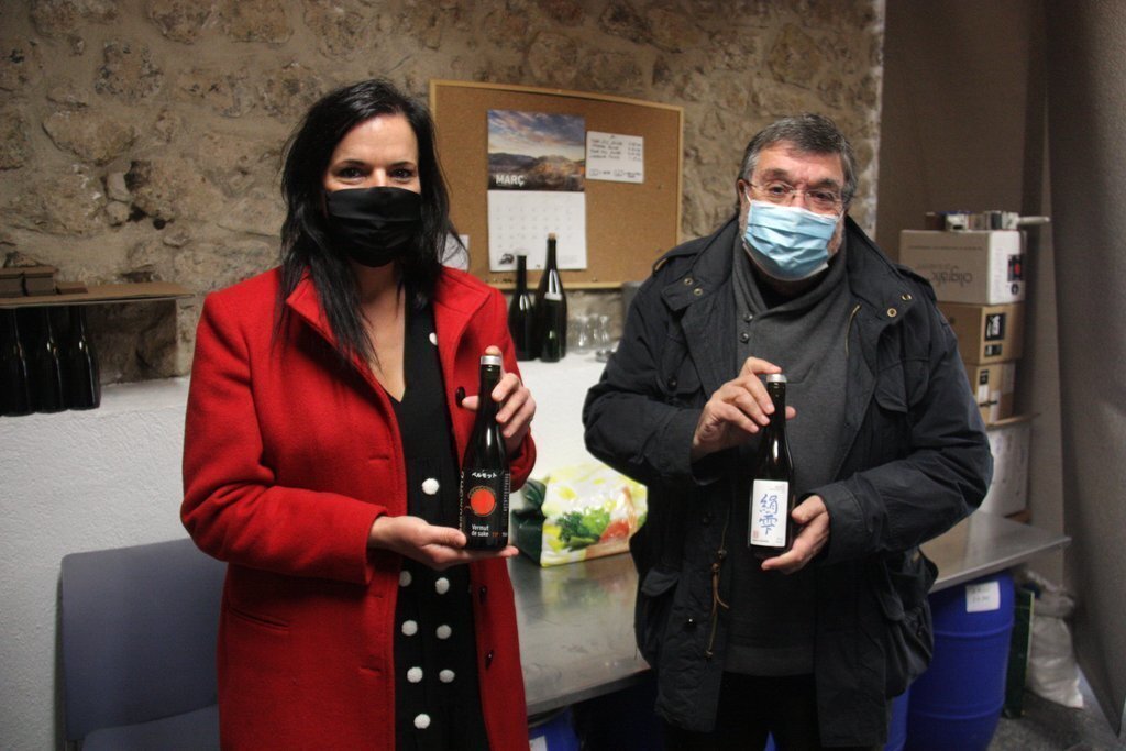 Pla americà de l'alcaldessa de Josa i Tuixén, Marta Poch, mostrant una ampolla de 'sake' elaborat al municipi al costat del seu productor, Antoni Campins. Imatge de l'1 de desembre de 2020 (Horitzontal).