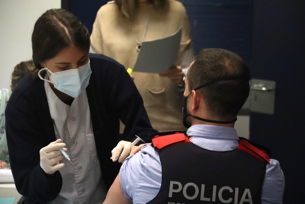 Pla mitjà on es veu una persona a punt d'administrar la vacuna de la covid-19 a un agent dels Mossos d'Esquadra de la comissaria de la Seu d'Urgell. Imatge del 10 de febrer de 2021 (Horitzontal).