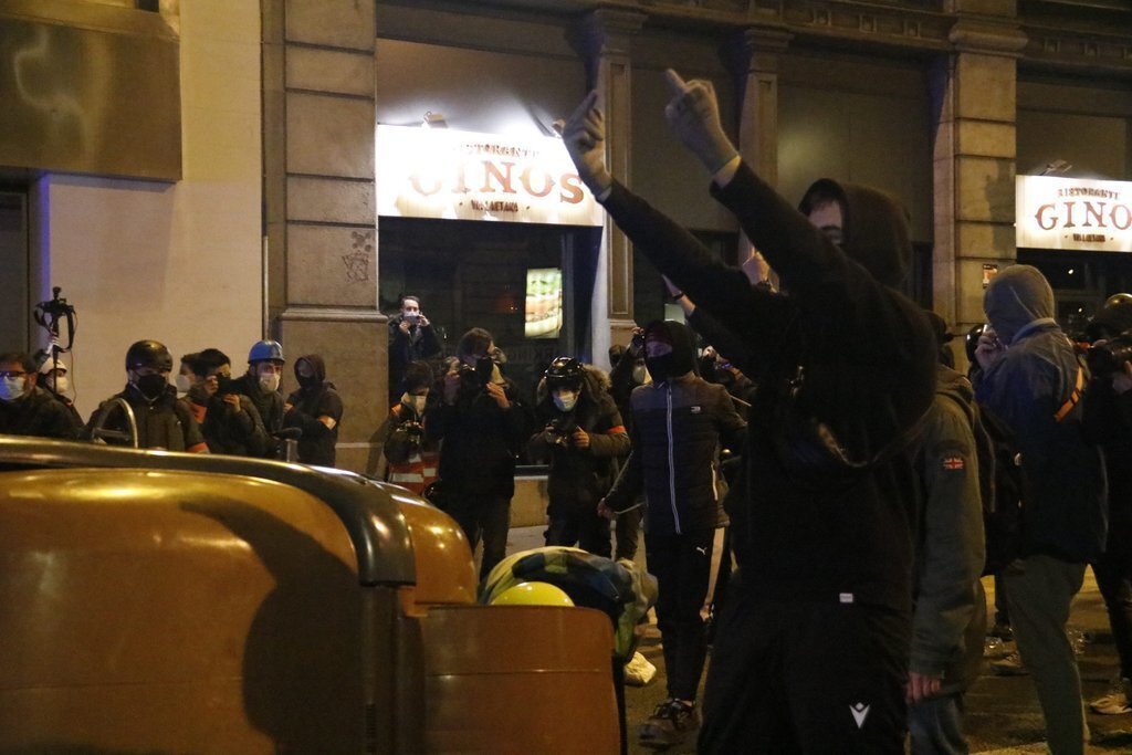 Un manifestant durant una protesta per l'empresonament del cantant Pablo Hasel el 17 de febrer del 2021 a Barcelona. Pla americà. (Horitzontal)