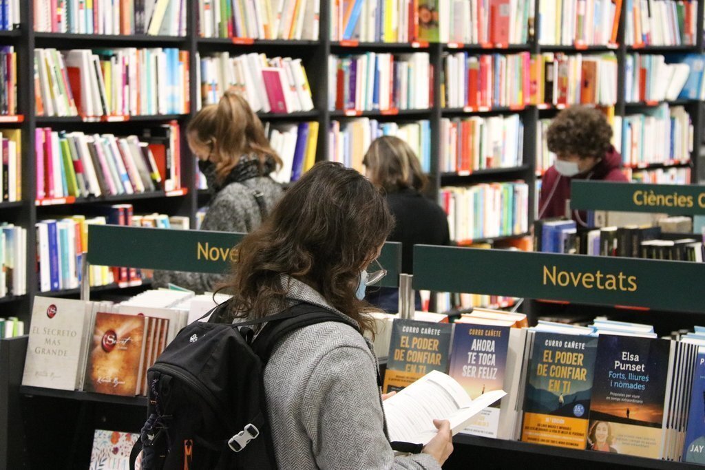 Pla conjunt de diverses persones mirant llibres en una llibreria. Imatge del 13 de febrer del 2021. (Horitzontal)