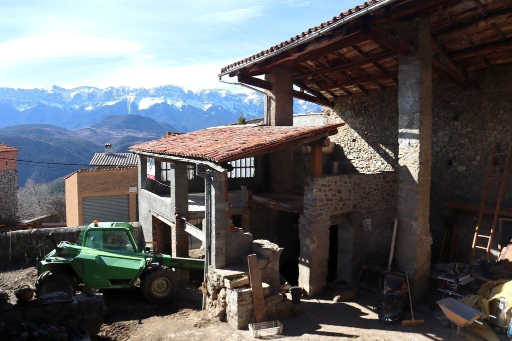 Pla general de l'antic galliner de la casa de Músser, a Lles de Cerdanya, que s'està rehabilitant per acollir el Taller d'Entorns dedicat a la creació artística amb la serra del Cadí de fons. Imatge del 16 de març de 2021 (Horitzontal).