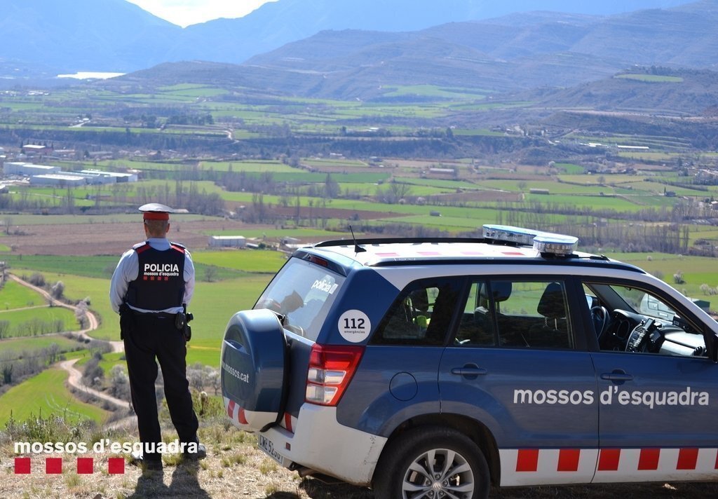 Pla sencer d'un agent dels Mossos d'Esquadra observant des d'un lloc elevat part del territori que forma part del Geoparc Orígens, el 25 de març del 2021. (Horitzontal)