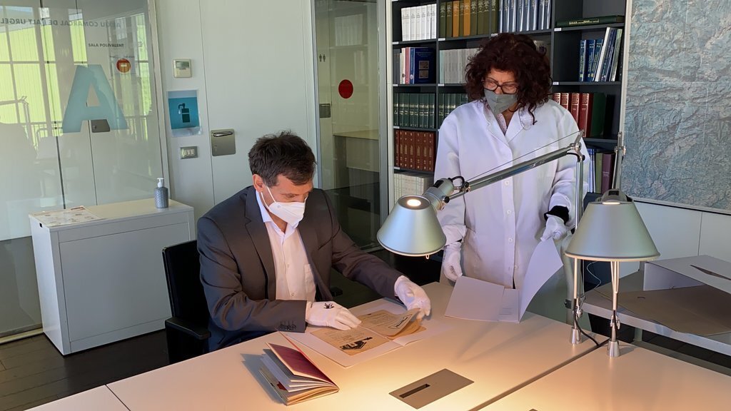 Pla obert del director de l'Arxiu Comarcal de l'Alt Urgell, Julio Quílez, i una treballadora de l'equipament, revisant un dels originals de la revista