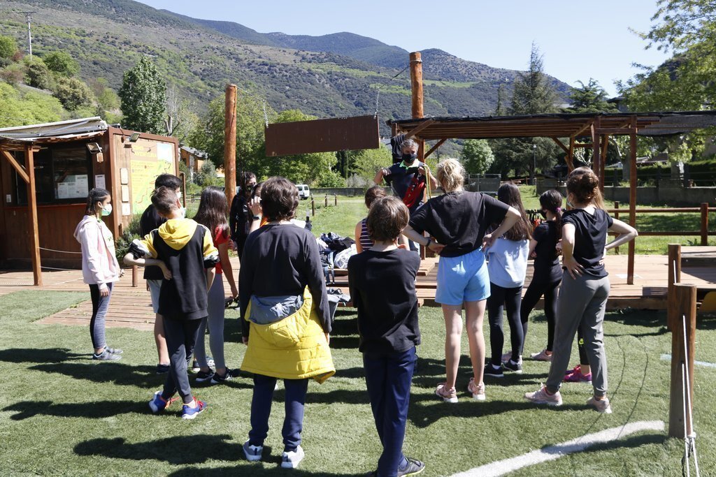 Pla general d'un grup de joves atenent les explicacions d'un monitor a un parc d'aventura de Rialp el 13 de maig del 2021. (horitzontal)