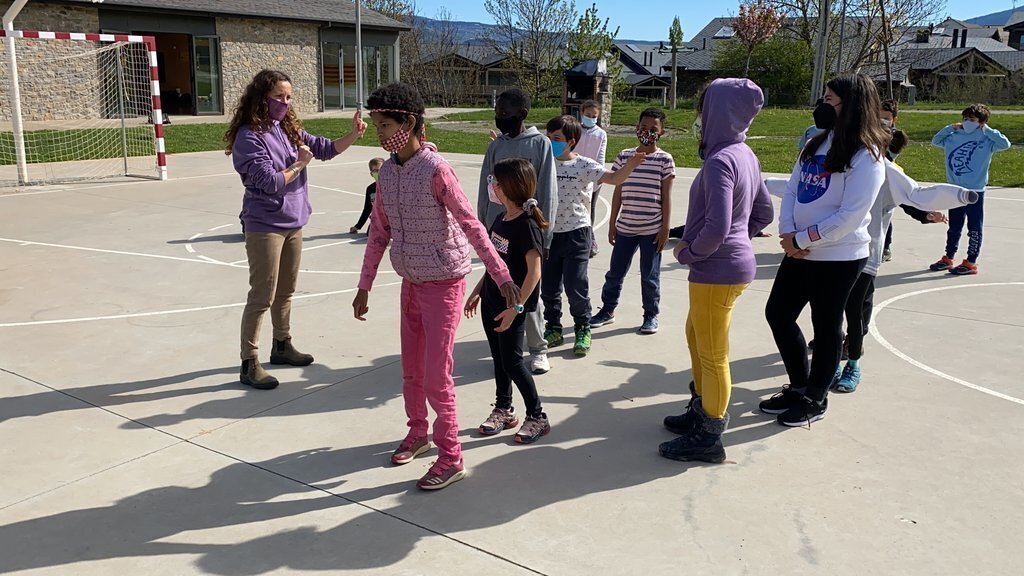 Pla tancat on es veuen diversos alumnes de l'escola Alfons I de Puigcerdà duent a terme una activitat de les jornades emocionals a l'exterior. Imatge del 13 de maig de 2021 (Horitzontal).
