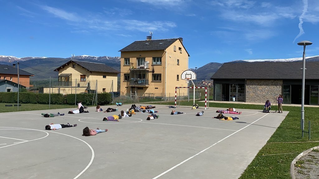 Pla obert d'un grup d'alumnes de l'escola Alfons I de Puigcerdà duent a terme un exercici de relaxació en el marc de les jornades emocionals a l'exterior. Imatge del 13 de maig de 2021 (Horitzontal).