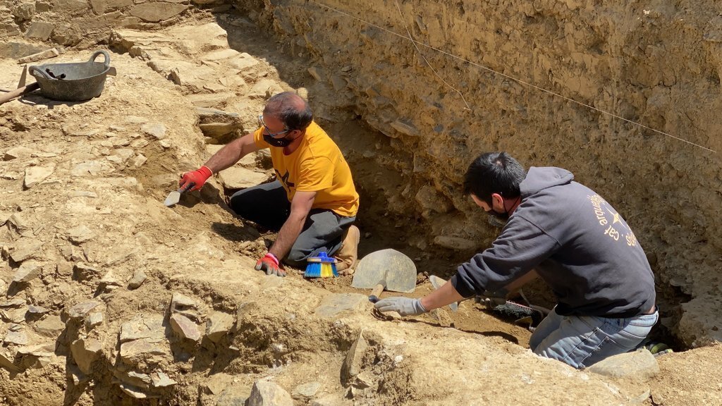 Pla de detall de dos arqueòlegs excavant al fòrum romà 'Iulia Libica' situat a Llívia (Cerdanya). Imatge del 20 de maig de 2021. (Horitzontal).