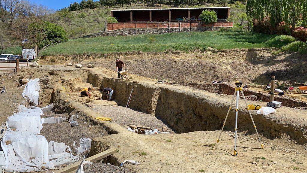 Pla obert d'una part del fòrum romà 'Iulia Libica' excavada i, al fons, un equip d'arqueòlegs treballant en aquest jaciment situat a Llívia (Cerdanya). Imatge del 20 de maig de 2021. (Horitzontal).