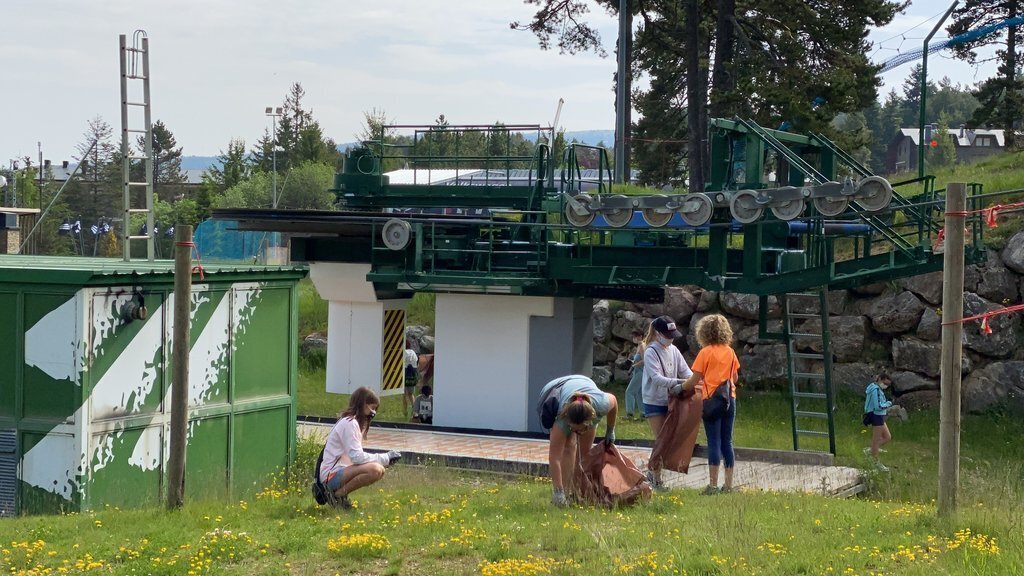 Pla obert de diversos alumnes de l'Escola Bac de Cerdanya d'Alp recollint residus a l'entorn d'un remuntador de l'estació de La Molina. Imatge del 16 de juny de 2021. (Horitzontal)