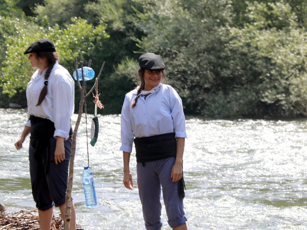 Pla mitjà de dues raieres damunt d'un rai abans de baixar el riu Noguera Pallaresa en la 43a Diada dels Raiers de la Pobla de Segur, el 4 de juliol de 2021. (Horitzontal)