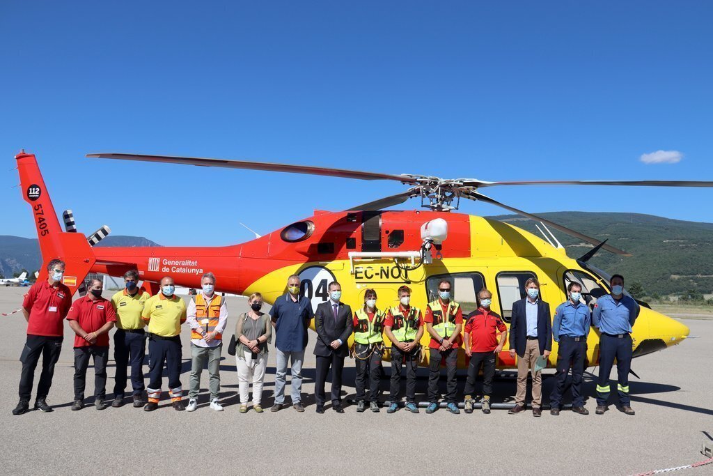 Pla general de diverses autoritats i professionals de Bombers i del SEM, al costat del nou helicòpter de rescat amb personal mèdic del SEM i base permanent al Pirineu que s'ha presentat a l'aeroport de la Seu. Imatge del 5 de juliol de 2021. (Horitzontal)