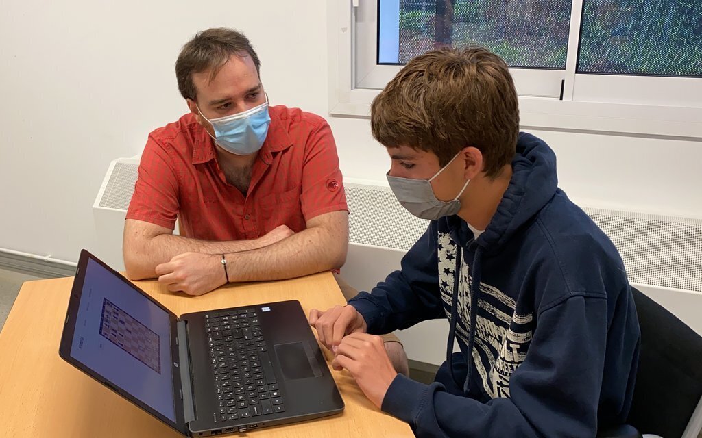 Pla mitjà de l'alumne de l'Institut La Valira, Markus Urban, mostrant l'algorisme que ha creat per jugar a escacs al seu tutor i professor de Tecnologia, Marc Llovera. Imatge publicada el 8 de juliol de 2021. (Horitzontal).