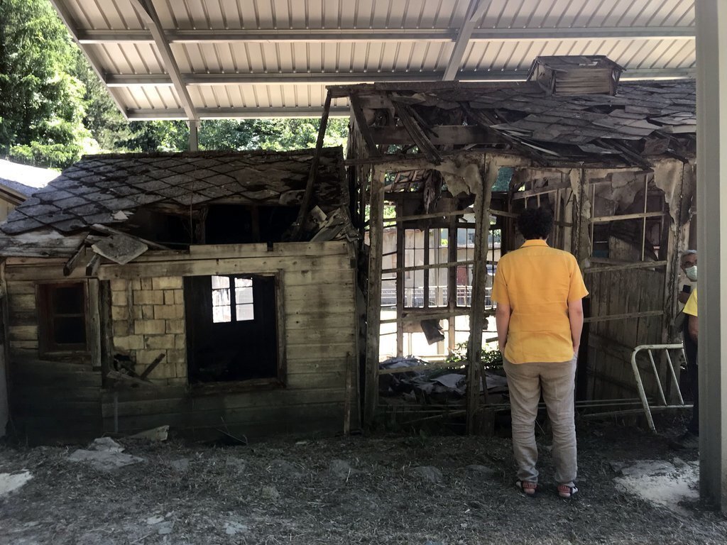Pla obert on es veu una persona, d'esquena, mirant part de l'edifici de l’Hospital de cartró de la Vall Fosca. imatge del 9 de juliol de 2021. (Horitzontal)