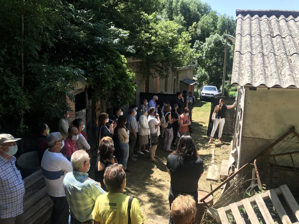 Pla obert d'un moment de la visita a l’Hospital de cartró de la Vall Fosca on es veu l'arquitecta iniciadora de la recerca, Sigrid Remacha, fent de guia als veïns. Imatge del 9 de juliol de 2021. (Horitzontal)