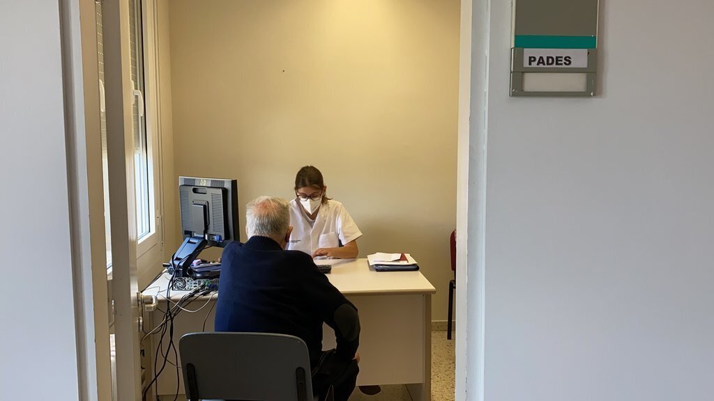 Pla general de la nova consulta de geriatria del PADES Cerdanya, a les instal·lacions de la Fundació Hospital de Puigcerdà, on es veu la geriatra Alba Roig atenent un pacient. Imatge del 22 de juny de 2021. (Horitzontal)