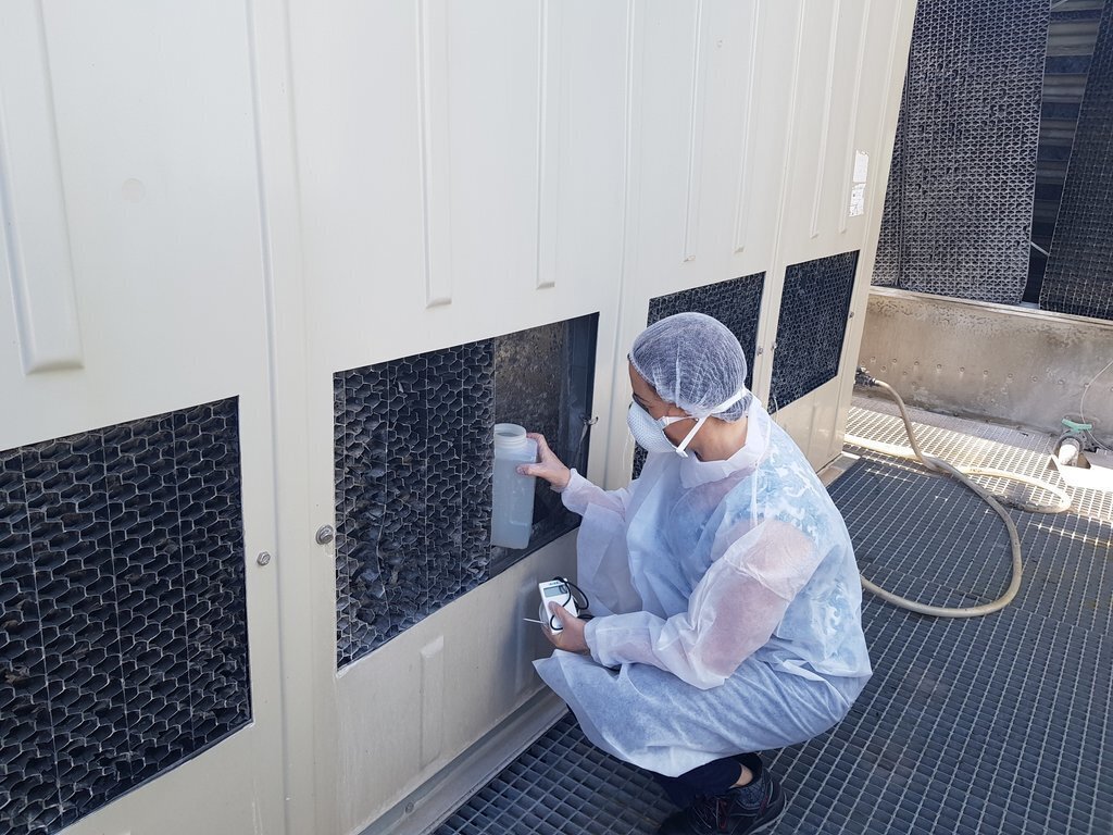 Pla obert on es veu personal de l'Agència de Salut Pública recollint una mostra d'una torre de refrigeració per analitzar si hi ha legionel·la. Imatge del 13 de juliol de 2021. (Horitzontal)
