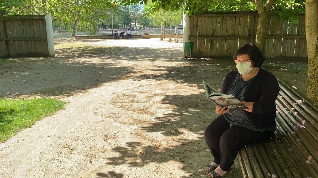 Pla general de l'escriptora Sandra Adam asseguda en un banc del Parc Schierbeck de Puigcerdà fullejant el seu nou llibre 'L'estiueig a la Cerdanya'. Imatge publicada el 14 de juliol de 2021. (Horitzontal) 