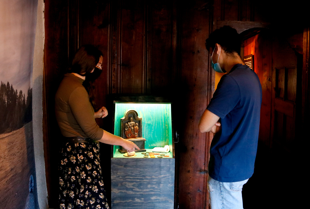 Pla general del plafó de la mostra 'Se'n parlave...i n'hi havie' on s'exposen les peces de cera fetes amb els ciris beneïts per Setmana Santa i amb imatges del calvari de Crist impreses. Imatge del 10 d'agost del 2021. (Horitzontal)