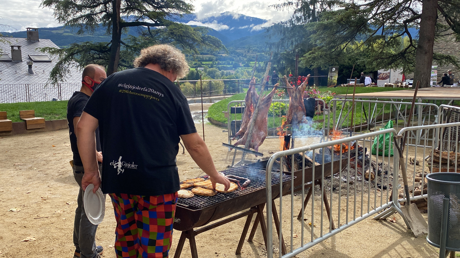Pla americà on es veuen dos cuiners fent tres xais a la creu al Parc del Cadí de la Seu d'Urgell en el marc de la trobada del col·lectiu de Cuineres i Cuiners Slow Food Km0. Imatge del 4 d'octubre de 2021. (Horitzontal)