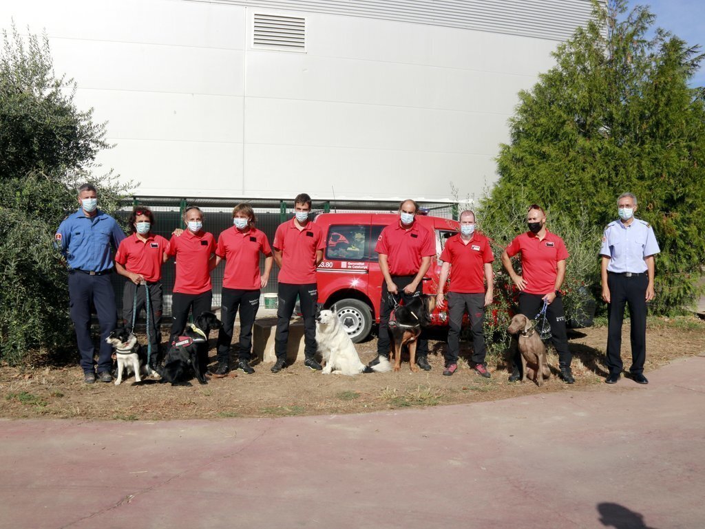 Foto de grup d'alguns dels integrants del Grup Caní de Recerca dels Bombers de la Generalitat al parc de Lleida, l'1 d'octubre de 2021. (Horitzontal)
