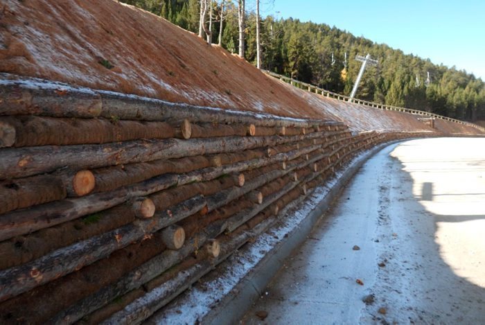 Pla de detall els murs de contenció de l'illa central de l'aparcament de Port Ainé (Pallars Sobirà), construïts amb troncs d'arbres de la zona. Imatge del 3 de novembre de 2021. (Horitzontal)