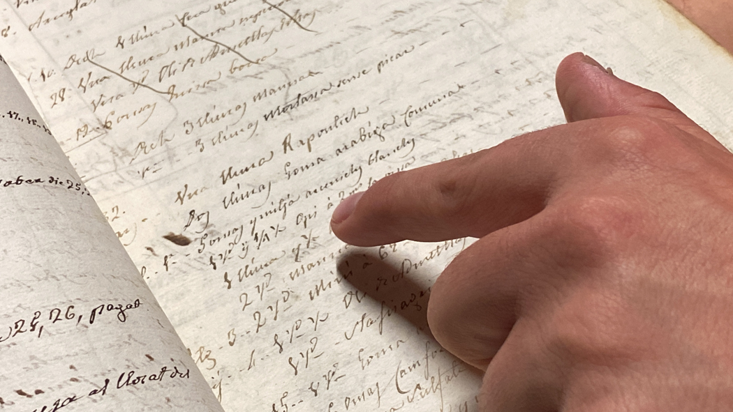 Pla de detall d'una plana d'un dels volums del fons bibliogr√†fic de l'antiga farm√†cia Esteva on es veu, entre d'altres, que es venia opi. Imatge del 16 de novembre de 2021. (Horitzontal)